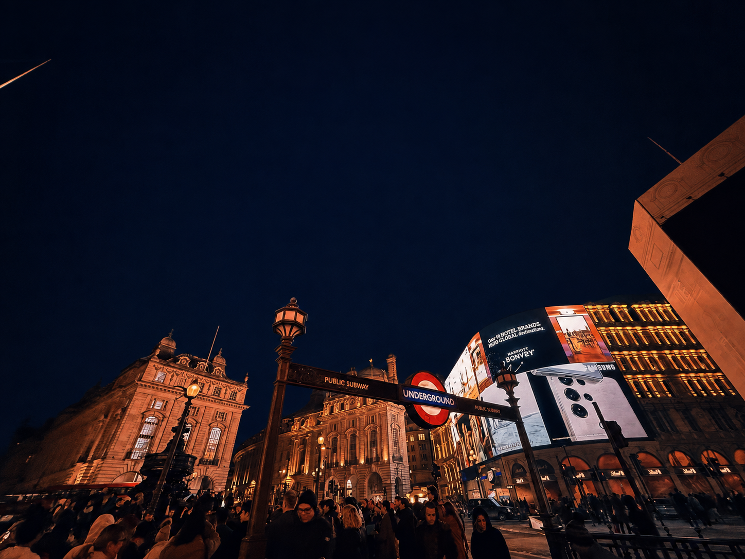 Piccadilly Circus and an Underground sign at night in London